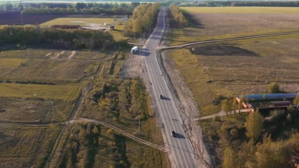 Arieller Blick auf weißes Auto, das sich auf Landstraße bewegt. — Stockvideo