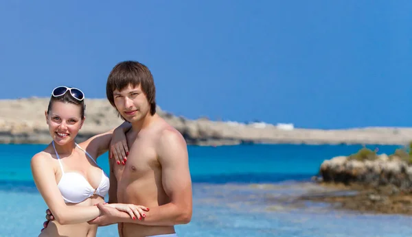 Улыбающаяся счастливая пара, стоящая вместе на пляже — стоковое фото