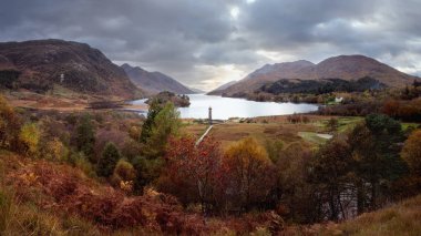 İskoçya 'nın ünlü gölü Loch Shiel ile gün batımında Glenfinnan anıtıyla panoramik manzara.