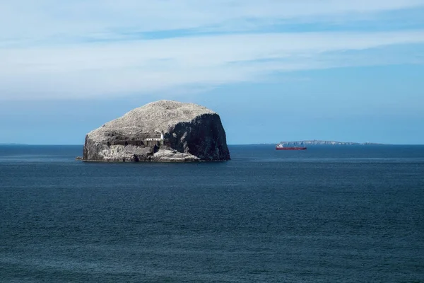 Farol em um penhasco, mar, gaivotas e navio vermelho — Fotografia de Stock