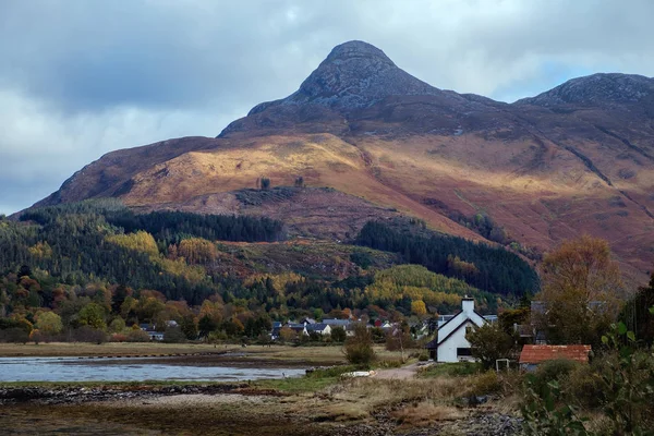 Schots dorp aan de voet van een enorme berg — Stockfoto