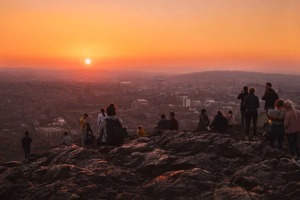 Turister Från Baksidan Ett Högt Berg Tittar Solnedgången Över Staden — Stockfoto