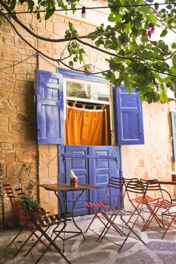 Aegina, Yunanistan, - 22 Ağustos 2018, Aegina caddesindeki kafe, renkli masaları olan büyüleyici bir kafe, Aegina, Yunanistan.