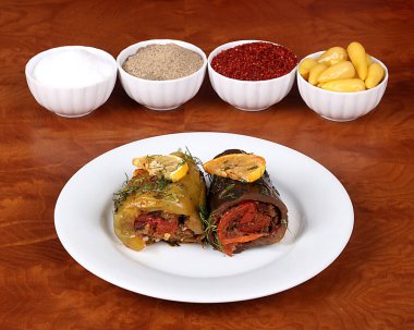 Patlıcan ve yeşil dolmalık biber lezzetli sebzelerle ahşap bir masada Türk baharatlarıyla servis edilmeye hazır.