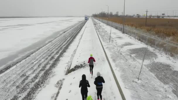 Rostov-sul-Don, Russia - febbraio 2019: le ragazze corrono lungo una pista innevata in inverno, vista dal retro, dall'alto — Video Stock