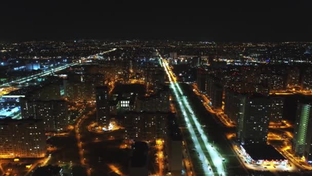 Hermosa ciudad moderna por la noche desde arriba. Luces nocturnas de la ciudad: la luz en las ventanas y los faros de los coches — Vídeo de stock
