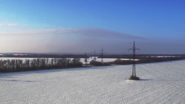 Power line pylons in a field in winter, Russia, aerial view — Stock Video