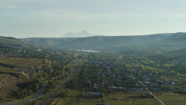 Casas en los suburbios. El ferrocarril. Paisaje de montaña, vista aérea — Vídeos de Stock
