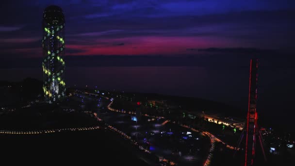 Батуми, Грузия - 2018: Алфавитная башня и колесо обозрения ночью сверху — стоковое видео