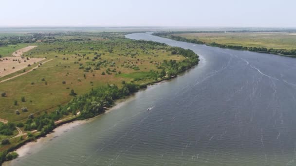 Uitzicht vanuit de lucht: vlakte, boot gaat langs de rivier, zomerdag — Stockvideo