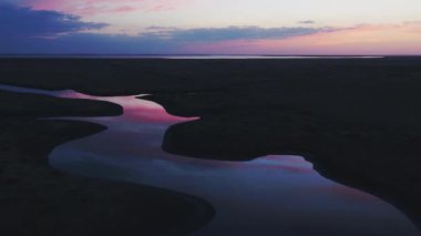 Hava manzarası: Gün doğumunda nehir, suya yansıyan güzel pembe gökyüzü.