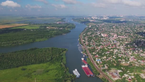 Aerial view: city by the river, barges and boats, green meadows and forests — Stock Video