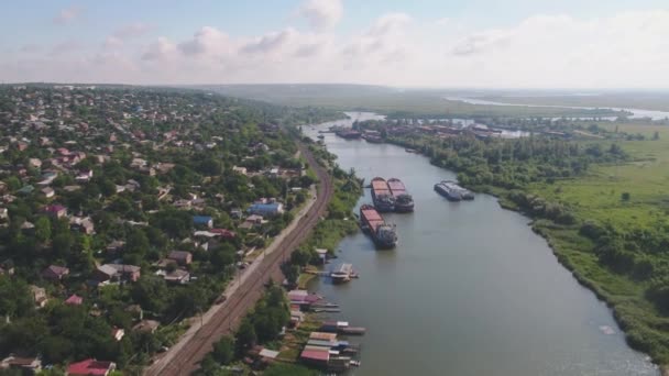 Aerial view: barges on the river, village on the shore, shipyard — 비디오