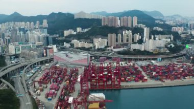 Hong Kong, China - 2020: loading containers onto a ship, city from above