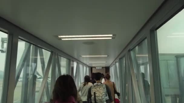 Hongkong, China - 2020: Passagiere passieren einen gläsernen Tunnel am Flughafen — Stockvideo