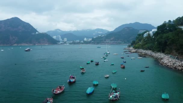 Empty boats swing on the waves near the rocky shore, aerial view — Stock Video