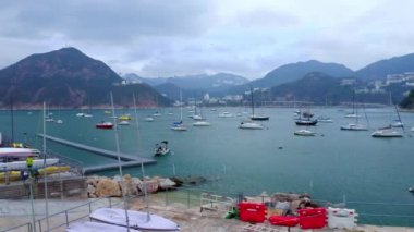 Deniz koyundaki yatlar, uzun direkler, temiz su, dağın çevresi, hava manzarası.