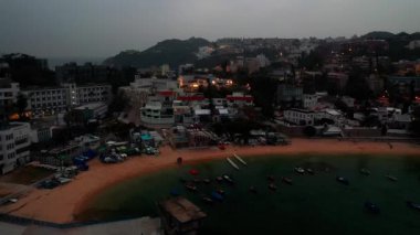 Hong Kong - 2020: sea bay, pier and boats near a shore at twilight, aerial view