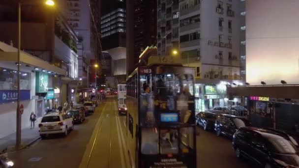 Hong Kong, China - 2020: Los tranvías de dos pisos recorren la calle por la noche — Vídeo de stock