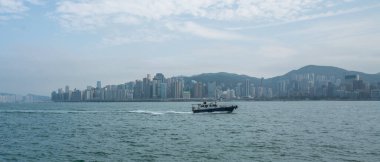 Hong Kong - 2020: Victoria Limanı 'nda tekne, Hong Kong gökdelenlerinin silueti.