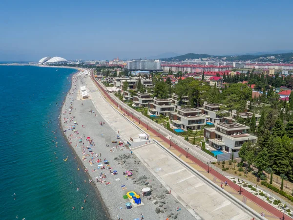 Menschen am Strand. Meer, Küste, Sonnenschirme, Promenade und Luxuswohnungen. Luftaufnahme. — Stockfoto