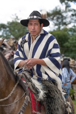 27 Mayıs 2017 Sangolqui, Ecuador: yerli quechua kovboy Andes kırsal bir rodeo geleneksel yün panço giyen at sırtında