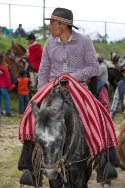 27 Mayıs 2017 onun kucağına kırsal bir rodeo Sangolqui, Ecuador: kovboy geleneksel yün panço ile sırtında Andes üzerinden katlanmış