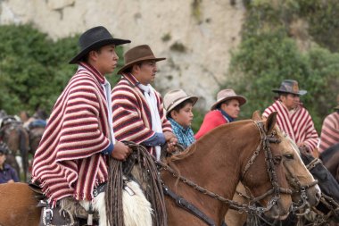 27 Mayıs 2017 Sangolqui, Ecuador: Yerel kovboylar kırsal rodeo izlerken geleneksel yün panço giyiyor