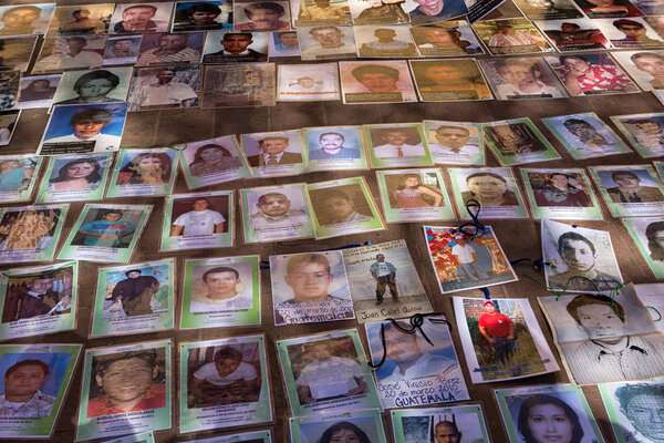 December 3, 2014 San Cristobal de las Casas, Mexico: photos of central American refugees who disappeared while crossing Mexico laid out on the ground during a demonstration