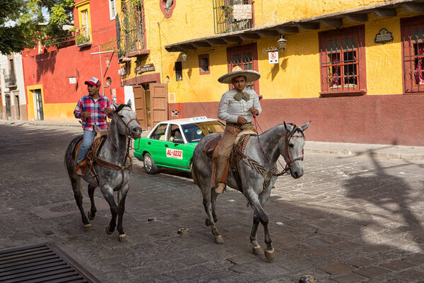 19 ноября 2014 Сан-Мигель-де-Альенде, Мексика: такси, проходящее всадников в популярном туристическом курорте колониальный город
