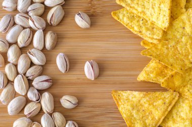 Dağınık Meksika üçgen mısır cipsi Nacho peynirli sağ tarafında ve sol tarafta kırık ve bütün kabuklarında fıstık fındık