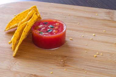 Meksika mısır cipsi cips baharatlı salsa dalış hafif kahverengi kesme tahtası üzerinde snack ve kırıntıları dağınık