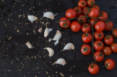 Domates ve sarımsak tarafta siyah arka plan ile dökülen baharat