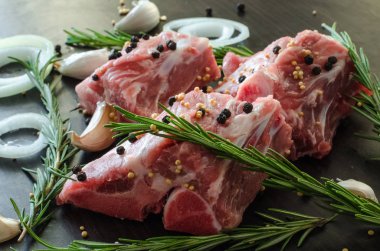 Karabiber üstte ve biberiye ile çiğ domuz eti? sarımsaklı, koyu arka plan, baharatlar, görünümü yan