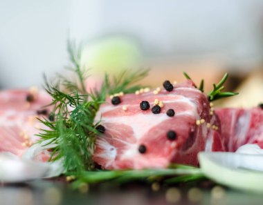 Dere otu, biberiye, sarımsak ve ışık arka plan üzerinde siyah biber ile kemikler üzerinde çiğ et