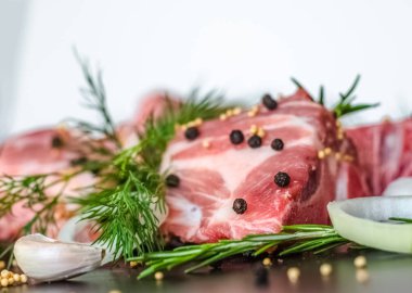 Çiğ et kemik ve dereotu, biberiye, sarımsak ve baharat ışık zemin üzerine siyah biber ile