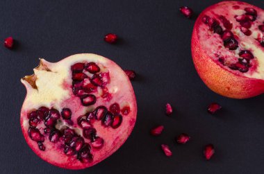 Nar ve koyu arka plan üzerine dökülen tohum iki yarısı