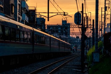 Tokyo'da bir gün batımına doğru çıkış yapan bir yolcu treni.