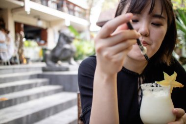 Güzel genç bayan tatilde kokteyl içiyor.