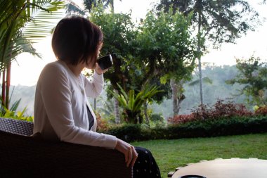 Genç ve güzel bir kadın sabahları çay içiyor ve dinleniyor.