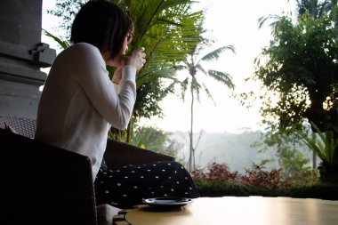 Genç ve güzel bir kadın sabahları çay içiyor ve dinleniyor.