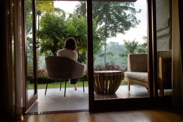 Küçük bir sehpada dinlenen genç bir kadın.