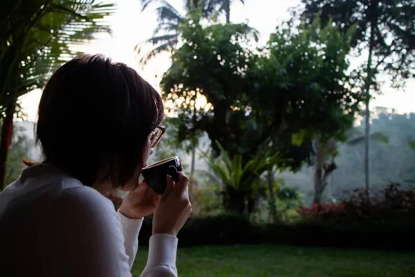 Genç ve güzel bir kadın sabahları çay içiyor ve dinleniyor.