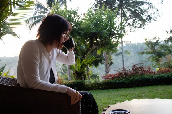 Genç ve güzel bir kadın sabahları çay içiyor ve dinleniyor.