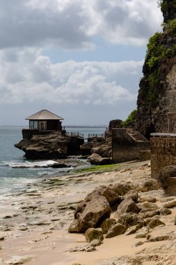 Deniz kenarında ahşap bir kulübesi olan güzel bir sahil manzarası.