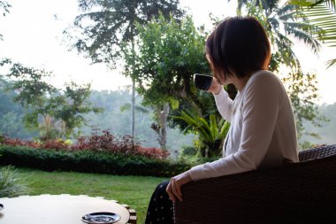 Genç ve güzel bir kadın sabahları çay içiyor ve dinleniyor.