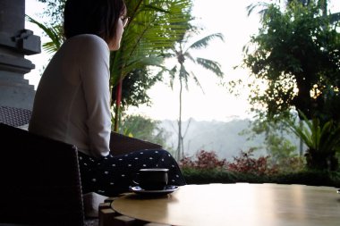 Genç ve güzel bir kadın sabahları çay içiyor ve dinleniyor.