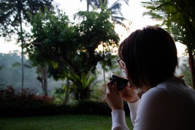 Genç ve güzel bir kadın sabahları çay içiyor ve dinleniyor.