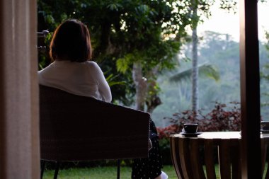 Genç ve güzel bir kadın sabahları çay içiyor ve dinleniyor.