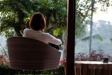 Genç ve güzel bir kadın sabahları çay içiyor ve dinleniyor.